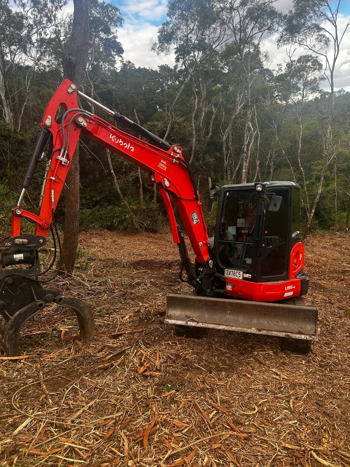 Red Kubota excavator on a mulched rural property in Queensland